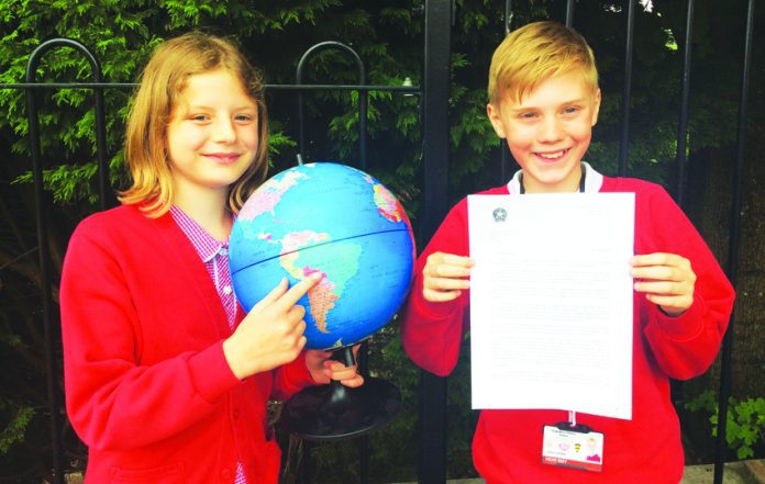 From left, head boy Wilson Gardner, (11), and head girl Amelia Banks, (11), receiving the letter on behalf of year six pupils.