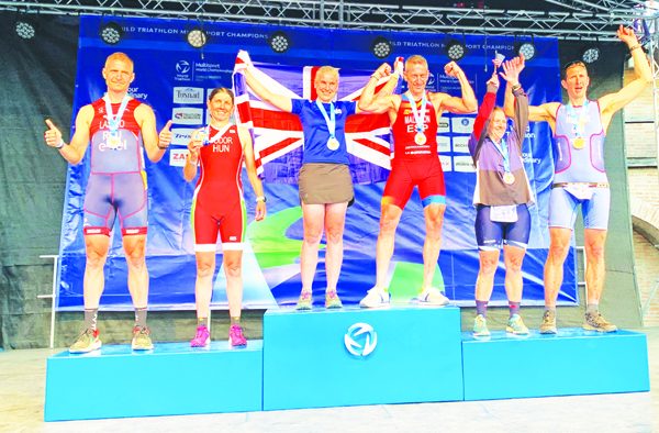 On top of the world: Mrs Heppenstall (centre) flies the flag in first place on the podium.